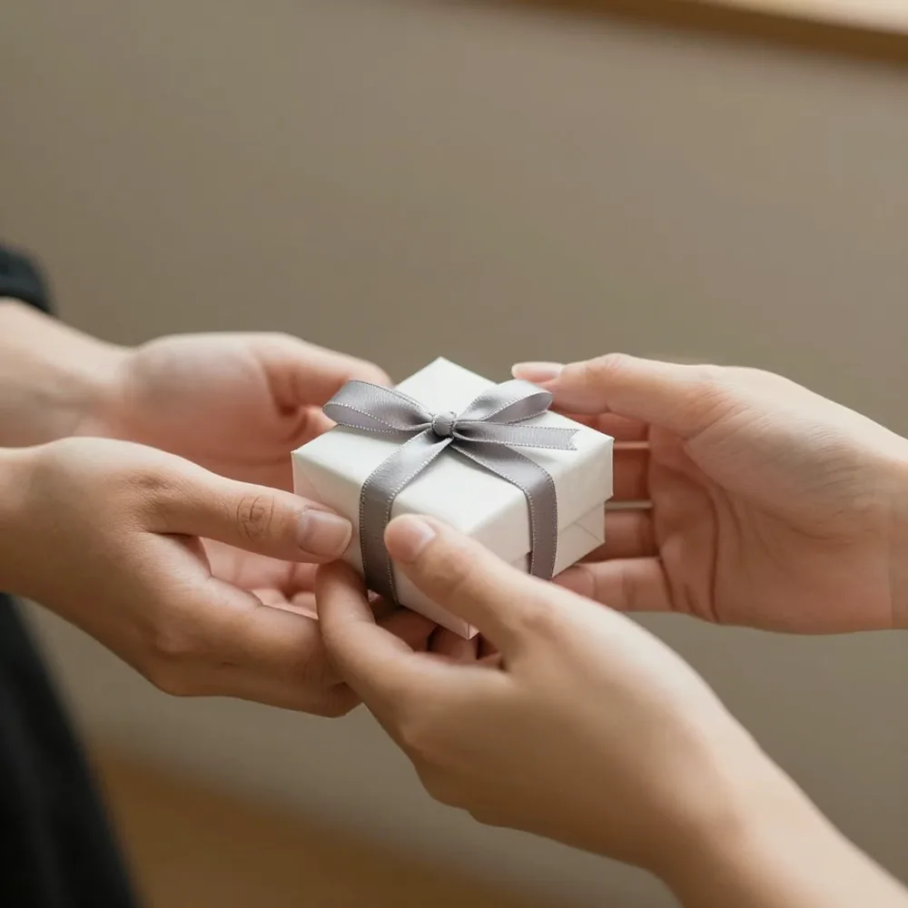 Entrega de una pequeña caja de regalo entre dos personas
