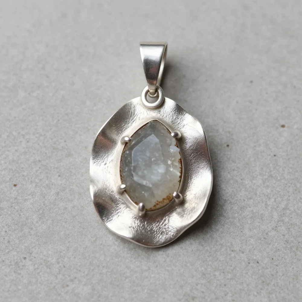 Colgante artesanal de formas orgánicas irregulares con piedra en bruto