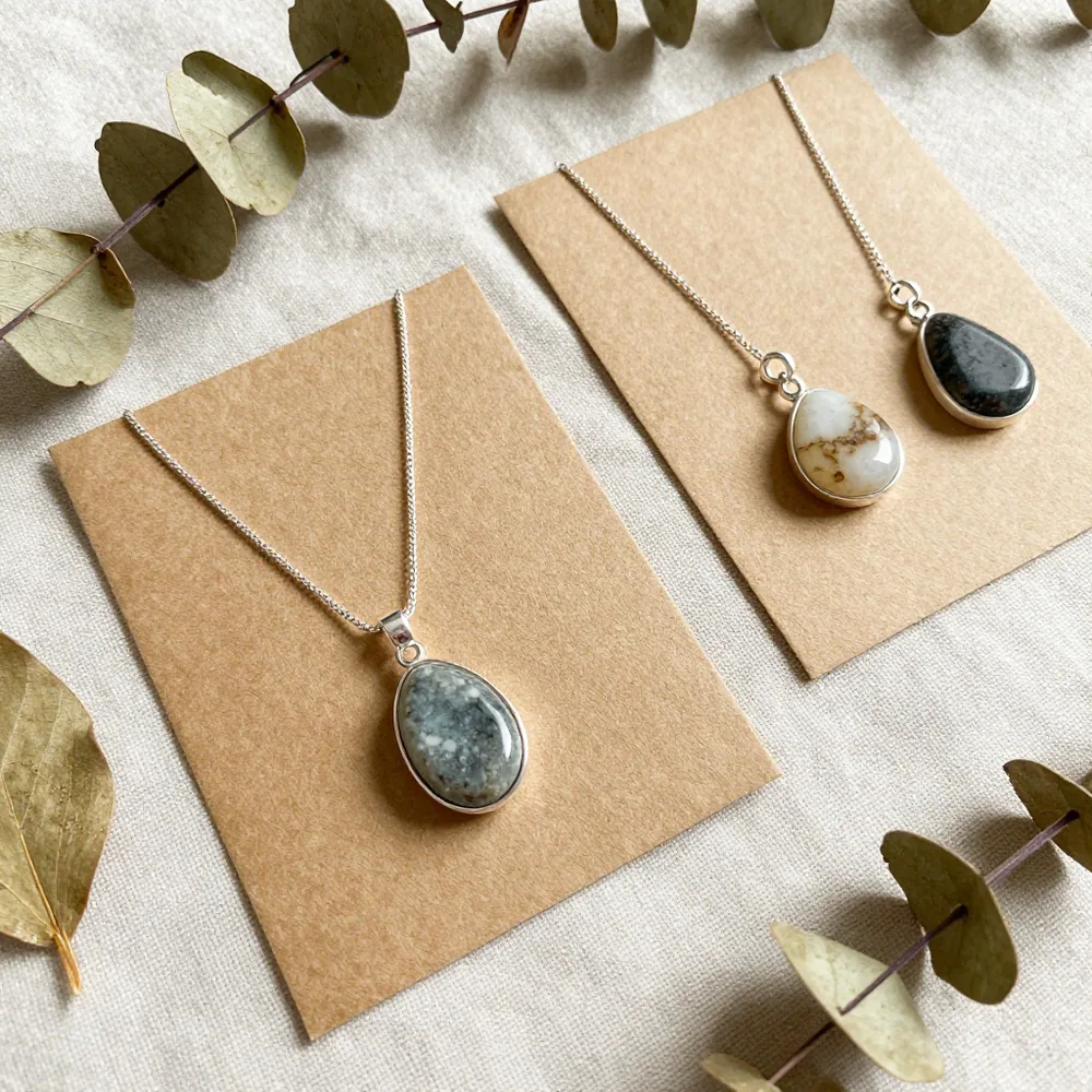 Joyas artesanales sostenibles con plata reciclada y piedras naturales sobre papel kraft
